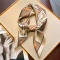 Dettaglio di un foulard di seta con motivi geometrici annodato in un fiocco chic - Stile Lettera Geometrica Marrone Caldo (FJ549-4)