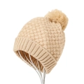 Primer plano de gorro de punto beige con pompón esponjoso y textura de panal en soporte - Albaricoque