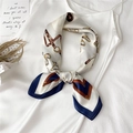 Close-up of a satin square scarf featuring equestrian patterns tied as a necktie - 70x70cm / Beige Navy