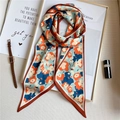 Vue détaillée d'une écharpe étroite en soie à imprimé floral abstrait sur un livre blanc - Bleu Clair Abstrait Fleuri Patchwork Bordure Orange (LE-72)