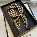 Dettaglio di un foulard quadrato in seta a scacchi neri e oro in un ambiente elegante - 70x70cm / Nero & Oro (FJ498-1)
