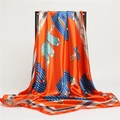 Dettaglio di un grande foulard in raso arancione con motivi a catena e cinture - 90*90cm / Arancione