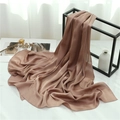 Detail of caramel silk scarf with accordion pleats hanging on a minimalist black frame - Pink Camel (TH35-28) / 180x70cm