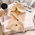 Dettaglio della maglia beige con bottoni color ambra e etichetta del marchio in pelle - Bianco Sporco