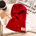 Dettaglio del passamontagna rosso in maglia grossa con bottoni in legno ed etichetta - Rosso
