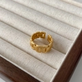 Close-up of gold-plated chain link ring with matte finish on a velvet jewelry display - Gold
