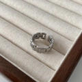 Silver chain-link wide band ring with adjustable open design on a beige velvet tray - Silver