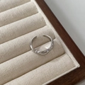 Detailed view of adjustable silver-tone ring with polished streamline design and texture - Silver