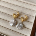 Vue macro des boucles d'oreilles perles baroques françaises avec fermoir en métal doré texturé - Doré