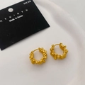 Primer plano de pendientes dorados mates con pliegues en bandeja con marca y plata 925 - Dorado