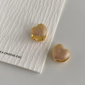 Detailopname van gouden hartvormige oorringen met een getextureerde kralenafwerking - Gouden Dubbelzijdige Hart Huggie Oorbellen