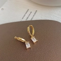 Gros plan sur des créoles dorées avec un pendentif rectangulaire en oxyde de zirconium - Boucles d'Oreilles Pendantes en Zircone Carrée Blanc Transparent Doré