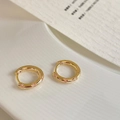 Macro-opname van 14K vergulde huggie oorbellen met micro-pave zirkonia kristallen - Micro Pave Oorbellen (Verguld) / Gouden Rond