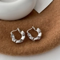 Detailopname van zilveren C-vormige oorbellen met rimpeltextuur op een bruine vilt - Groot (ongeveer 2,5 cm) / Zilver