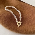 Dettaglio bracciale di perle barocche con chiusura OT a fiore dorato su tessuto - Bracciale / Circa 17cm