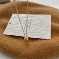 Detail einer minimalistischen Goldkugel-Halskette auf einer weißen Displaykarte - Goldene Kugel Anhänger Halskette