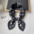 Dettaglio di un foulard in seta con motivi geometrici bianchi e neri su espositore - 70x70cm / Nero