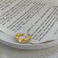 Makroaufnahme der goldenen Ohrmanschette mit birnenförmigem Zirkon und Mikro-Pavé - Gold Zirkonia Stil