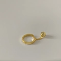 Detail of minimalist gold-plated chain ring with ball pendant on off-white background - Gold
