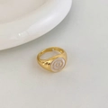 Detailed macro view of vintage gold ring with white enamel circle and concentric texture - Gold White Round Style
