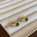 Dettaglio di orecchini vintage in oro con zirconi verde smeraldo, viola e bianchi - Oro