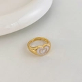 Detailed close-up of a vintage golden heart ring with pearl-like white enamel inlay - Gold White Heart