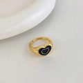 Detailed macro of vintage adjustable gold heart ring with black enamel drip oil finish - Gold Black Heart Style