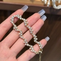 Elegante pulsera dorada con perlas y cristales en la mano para un aspecto de lujo - Pulsera de perlas de circón chapada en oro