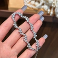 Elegante pulsera de plata con perlas brillantes y circonitas en una mano de mujer - Pulsera de perlas de circón chapada en plata