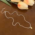 Detail van zilveren kralenketting met karabijnsluiting en gouden logo-tag op hout - Kleine Ovale Plaat Hanger (B-88)