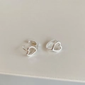 Detailed macro view of minimalist hollow heart-shaped silver huggie hoop earrings - Silver