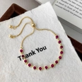 Detail of adjustable gold box chain bracelet with sparkling red round-cut gemstones - Gold Color Rose Red Zirconia Bracelet