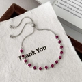 Detailed view of silver adjustable chain bracelet featuring fourteen inlaid red round stones - Silver with Rose Red Zircon
