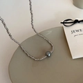 Detalle de finas cuentas metálicas plateadas con una perla gris oscuro brillante central - Collar Plateado (Con Perla Gris Oscuro)