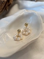 Dettaglio di orecchini a cerchio con perle d'acqua dolce su vassoio a conchiglia - Stile Perla d'Acqua Dolce e Sfera Dorata