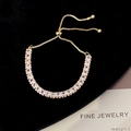 Detail of adjustable gold-plated bracelet with rectangular cubic zirconia stones - White