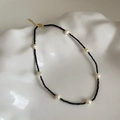 Detail of freshwater pearl and black crystal necklace on white ceramic tray - Seven Freshwater Pearls Black Beaded Necklace