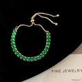 Detail of adjustable gold slider bracelet with emerald-cut green cubic zirconia stones - Green
