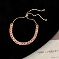 Close-up of gold adjustable pull-chain bracelet with pink baguette-cut zircons - Pink
