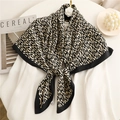 Elegante foulard in seta 90 cm con motivo geometrico nero e beige accanto a una rivista - 90x90cm / Logo Piccolo Nero Beige