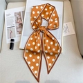 Close-up of orange silk twilly scarf with white polka dots on a stylish magazine layout - LE-29 Dark Yellow