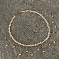 Detalle de collar de borlas de perlas de agua dulce con cadenas doradas sobre fondo oscuro - Collar de Borlas de Perlas Blancas