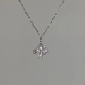 Macro detail van zilveren klaverhanger met glinsterende zirkonia steentjes aan een ketting - Zilver