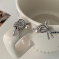 Macro detail of silver knot stud earrings with a single white pearl on a ceramic cup - Silver Knot Cotton Pearl Stud Earrings (Real Gold Plated)