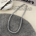 Detalle del collar de perlas grises sobre boina de lana con fondo vintage elegante - Perla Gris de 6mm (40cm)