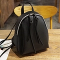Mini zaino nero in pelle sintetica con eleganti nappe a zip su superficie in legno - Nero