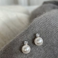 Close-up of pearl stud earrings with zircon inlay on grey knitted fabric background - White Pearl Zirconia Style (A-431)