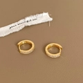 Makroaufnahme von vergoldeten Huggie-Ohrringen mit doppelten Reihen aus Zirkonia-Kristallen - Doppelreihige Zirkonia Huggie / Gold