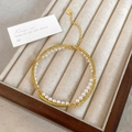Dettaglio bracciale a doppio strato con catena oro 18K, perle e ciondolo logo marchio - Bracciale di Perle Intrecciato a Doppio Strato