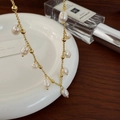 Detail view of a vintage gold-plated necklace with natural freshwater pearls on ceramic - Freshwater Pearl Tassel Necklace